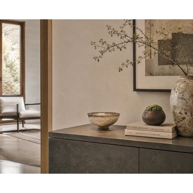 This beautifully crafted silver alloy bowl features a broad, shallow hemispherical form, with softly rounded sides...
