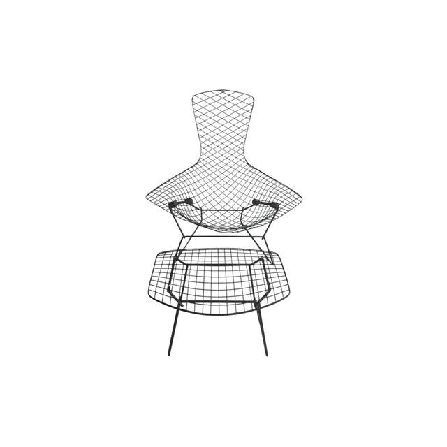 A black wire frame "Bird Chair" and ottoman set by Harry Bertoia for Knoll furniture. The seat is made of a wire mesh of...