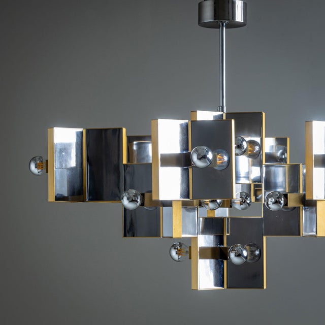 A large chandelier by renowned designer Gaetano Sciolari, made in Italy during the 1970s. This large chandelier features a...