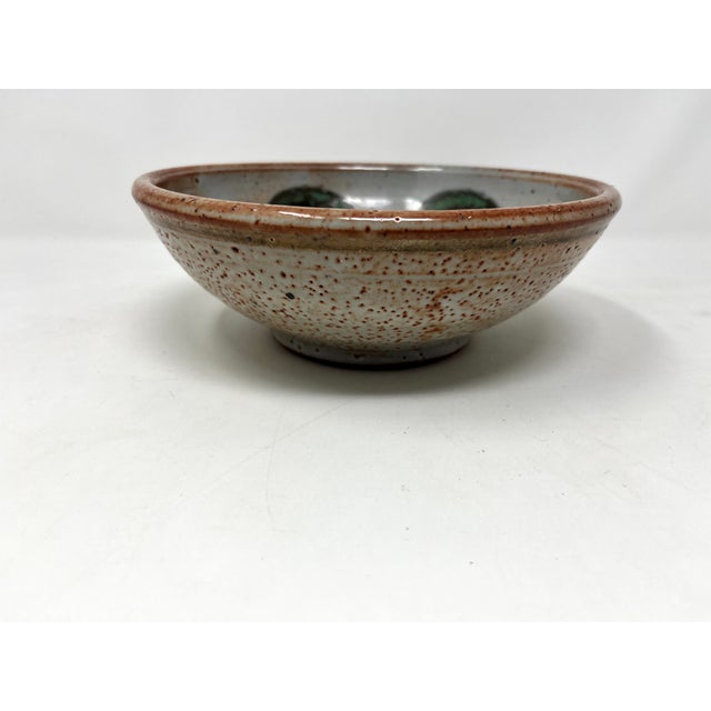 Medium-size glazed ceramic studio pottery bowl with heavy glaze depicting a repeating circular abstracted flower. Heavy...