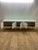 The Charlie credenza by Brueton is 19" x 84" x 29"H with a white high gloss finish and a 1/2" white laminated glass top....