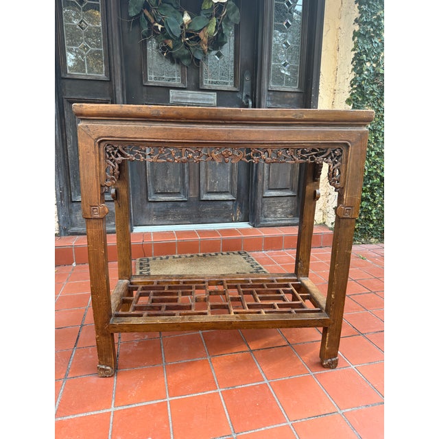 Early Asian console table. Carved floral and Greek key detail. Fretwork shelf.
