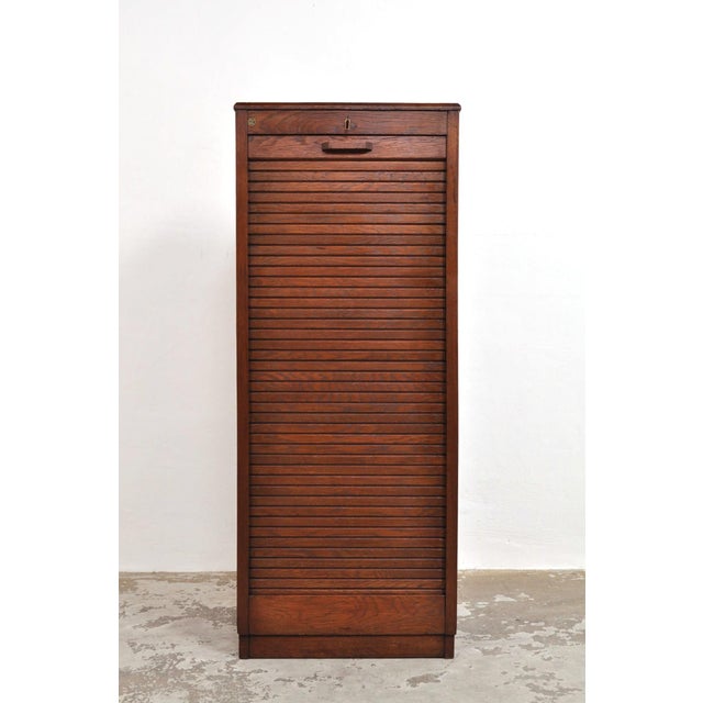 Despite its age, it is still in excellent condition. The oak cabinet features a smoothly operating roller door, a working...