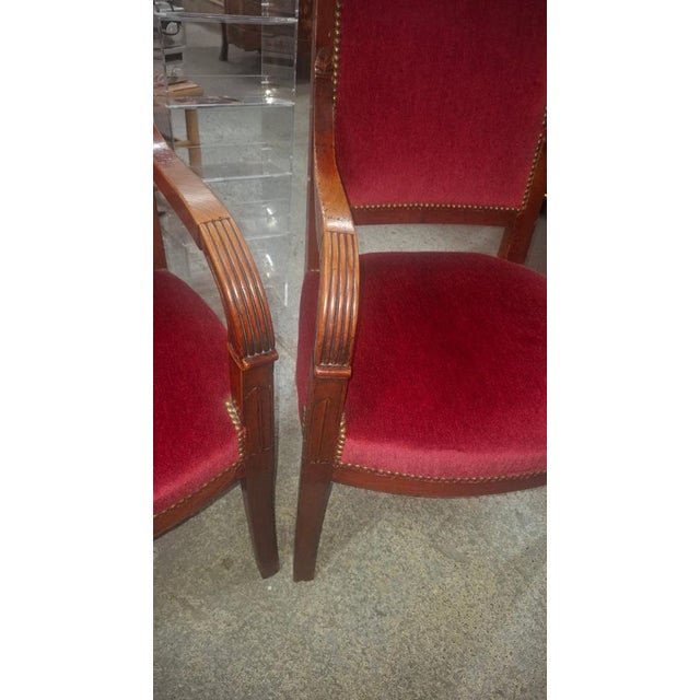 Pair of Empire period cherrywood armchairs. The upholstery and seats are in perfect condition on each chair. The chairs...