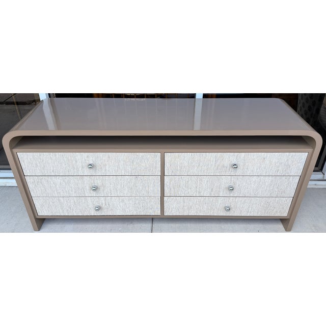 Cool 1970's dresser in a waterfall design. Taupe color mica. Six drawers covered in grasscloth and with chrome knobs....