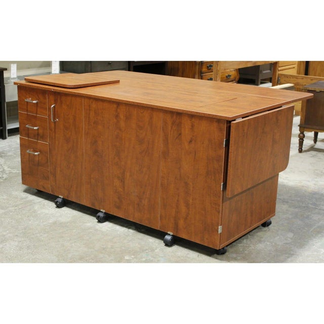 Finished in a warm medium wood veneer, this piece features an expansive work surface with fold-out extensions and a...