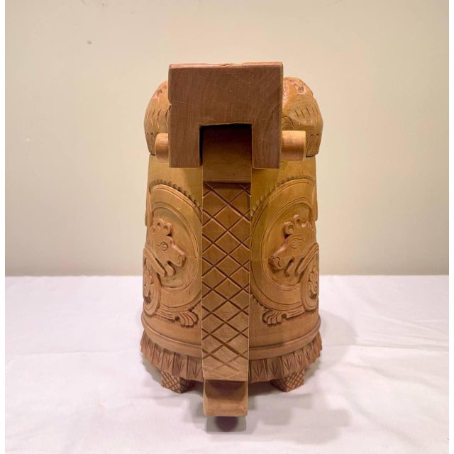 A striking vintage Norwegian hand-carved wooden tankard with a fitted lid, decorated with elaborate Viking-inspired and...