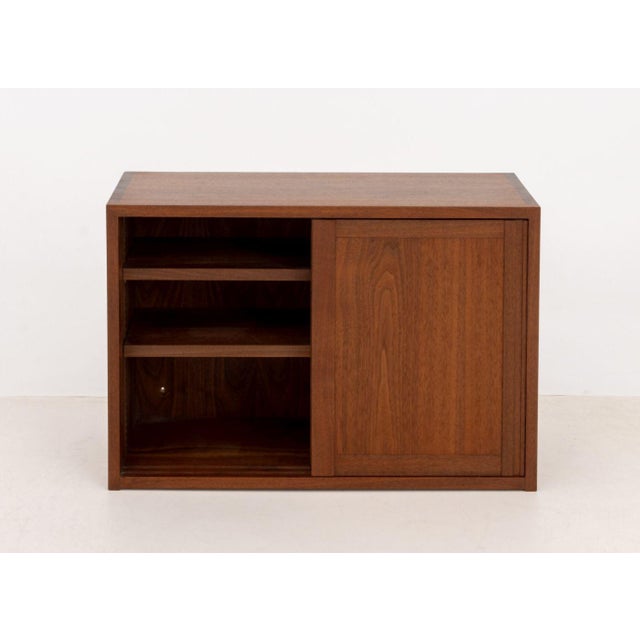 George Nakashima (American, 1909-1990) Walnut Wall-Hanging Cabinet, 1978, with two sliding doors opening to shelves, with...