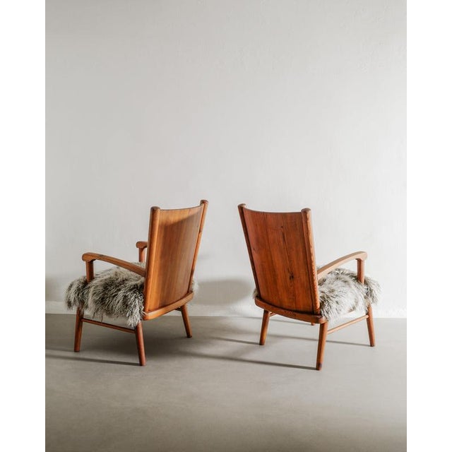 A very rare and most likely unique pair of early swedish mid century modern wooden armchairs in stained pine and newly...