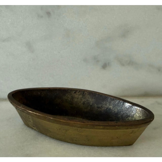 Vintage mid century solid brass boat shaped ashtray or catchall in the style of Carl Aubock. The piece has wonderful...