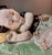 Chinese porcelain sculpture or pillow depicting a child sleeping with intricate floral and patterned clothing details.