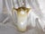 This is a cream and gold Reinhold Schlegelmil chocolate pot. It has gold trim, a white floral design and a matching lid....