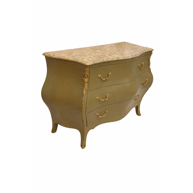 Walnut burl commode with brass hardware and handles and honed travertine top. The classic bombe silhouette is reimagined...