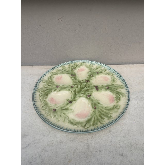 French Majolica oyster plate signed Hippolyte Boulenger Choisy-le-Roi. The six pink wells are surrounded by green seaweeds.