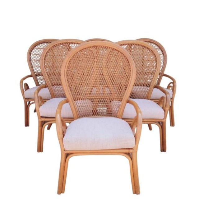 A fabulous set of 6 large fan back rattan Coastal Regency dining room chairs. The chairs feature a wide spread back with...