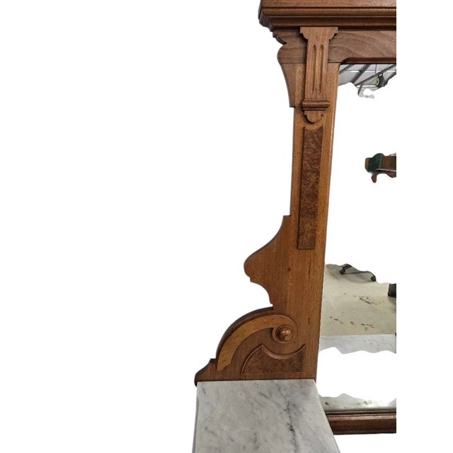 A striking antique Victorian Eastlake dresser featuring original marble top surfaces and richly carved solid wood...