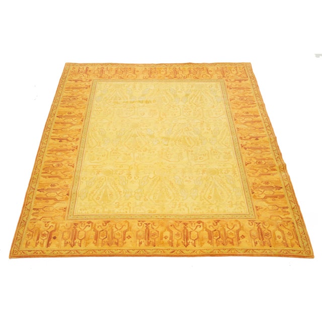 Hand-knotted Tibetan wool rug featuring a warm golden field with stylized floral and geometric motifs. The rich orange...