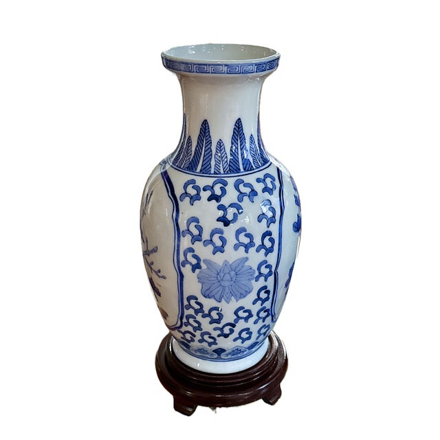 A beautifully hand‑painted blue‑and‑white Chinese porcelain vase featuring classic floral and bird motifs, displayed on a...