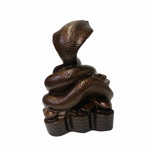 This is a Chinese Fengshui snake on an ingot figure made of metal in a painted metallic brown color with a precise accent...