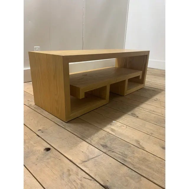 Kee Kee coffee table by Brueton. This custom shelved coffee table features a light golden brown finish with an open,...