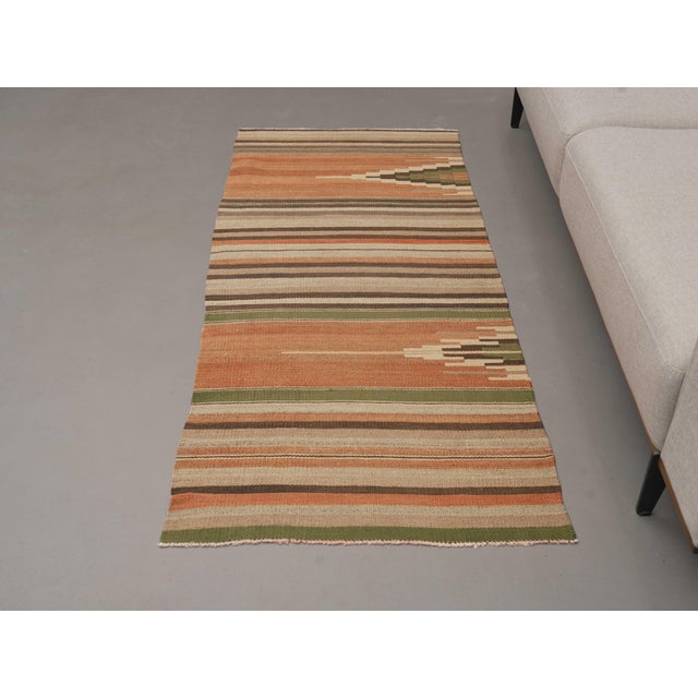 Vintage Hand-Knotted runner rug is a semi-antique vintage area rug. The '70s Eastern region of Anatolia's unique rug is...