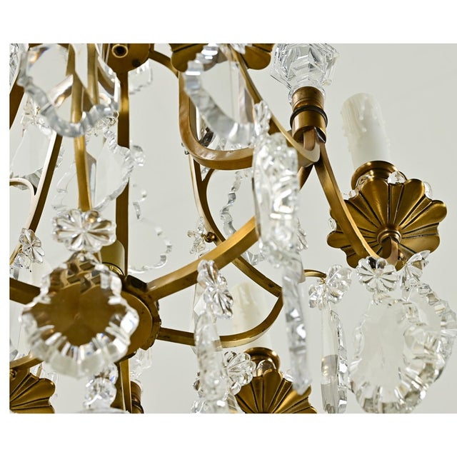 A petite French 6-light brass and crystal chandelier from the 1800s. Cut crystal drops and crystal floral designs hang...