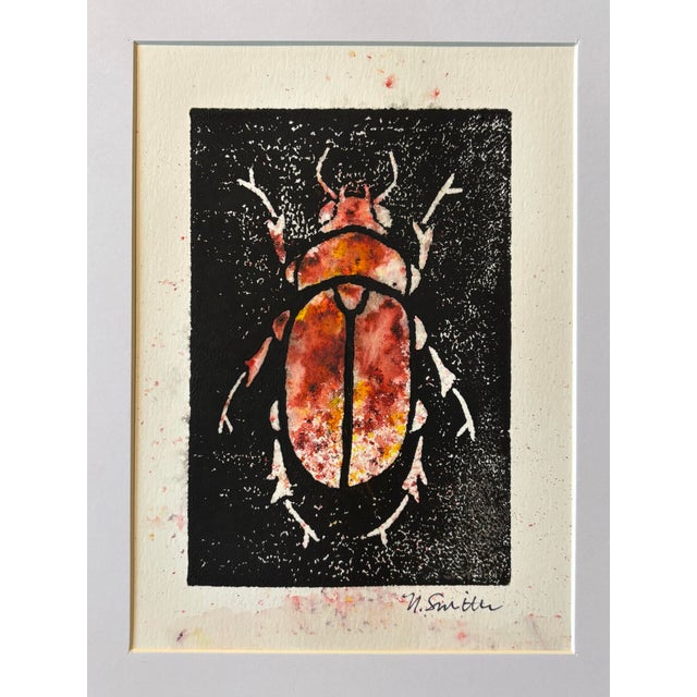 An original hand-carved block linocut featuring a detailed beetle motif, individually printed with black ink and finished...