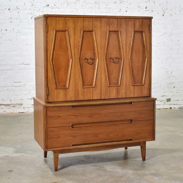Handsome mid-century gentlemen’s chest adorned with a hexagon paneled design and brass hardware and attributed to...