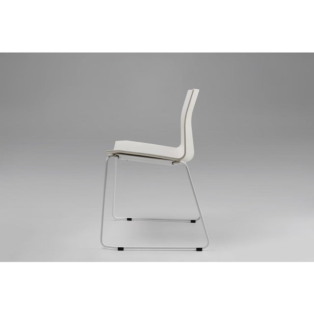 A sleek white chair with metal frame designed in Belgium. This stylish and functional chair is an asset for both outside...