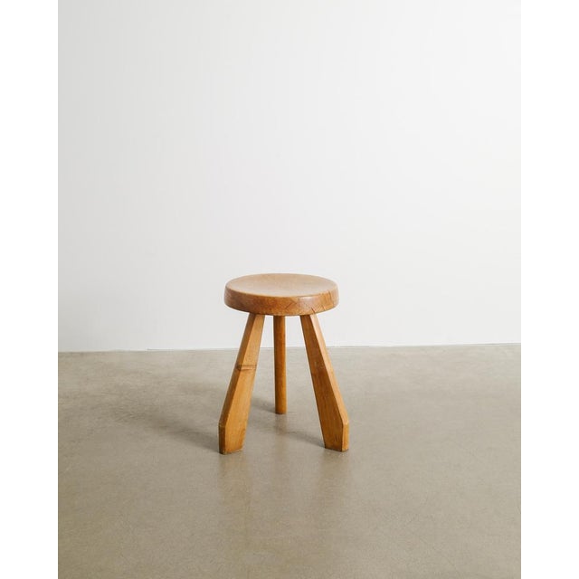 A rare French mid century wooden tripod "Sandoz" stool with three iconic sculptural legs and a slightly curved seat in...