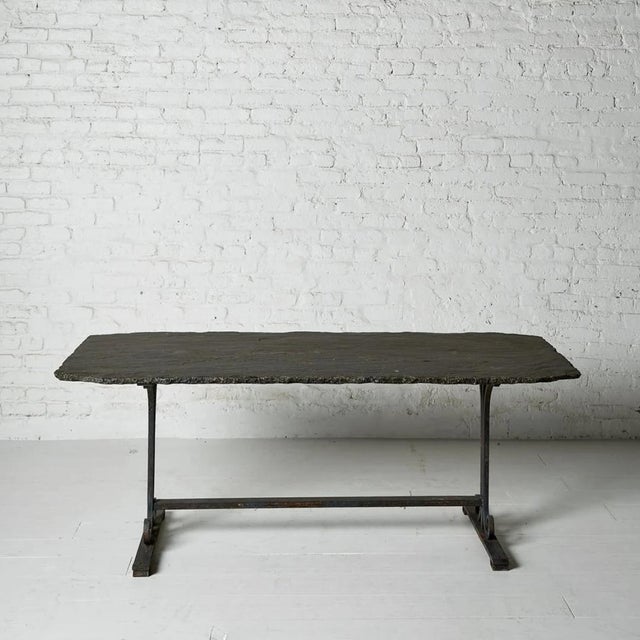 A strikingly handsome 19th century French table, featuring a substantial original slate top mounted on bold, architectural...