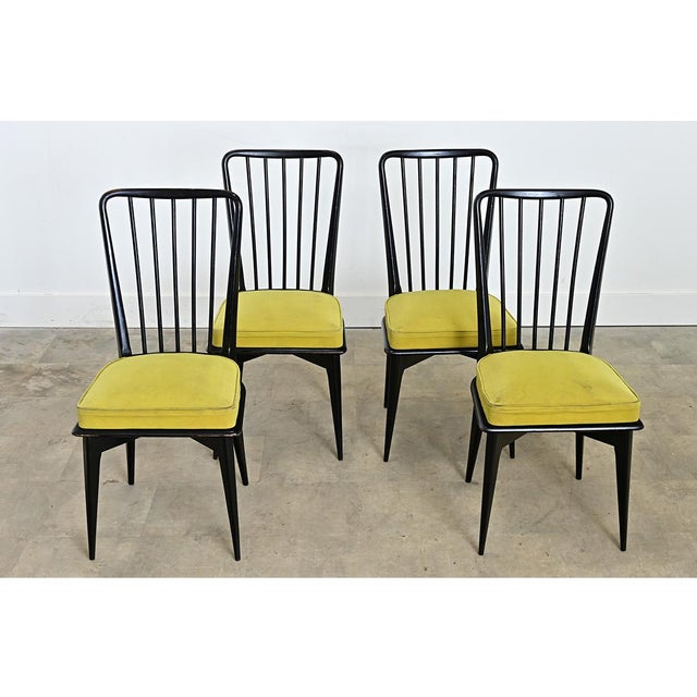 A sleek set of four dining chairs from mid-20th century France attributed to designer Charles Ramos. Their ebonized finish...
