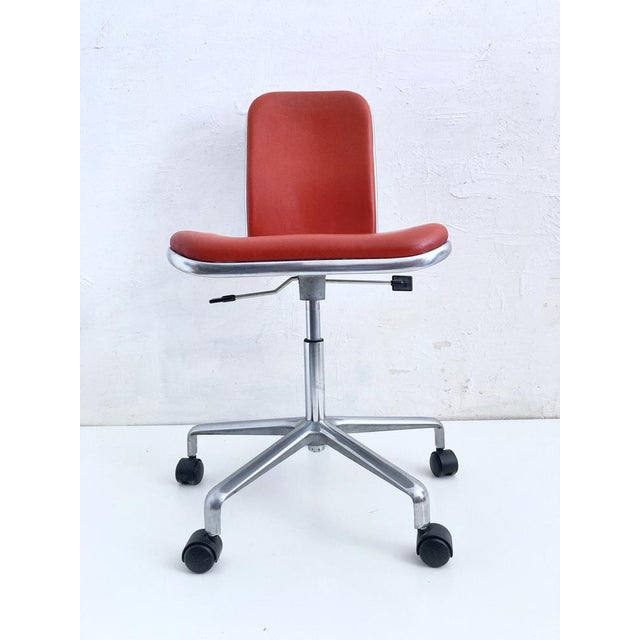 One height-adjustable, swivel desk chair, designed by Frederick Scott for Hille, England. The chair has casters and a tilt...