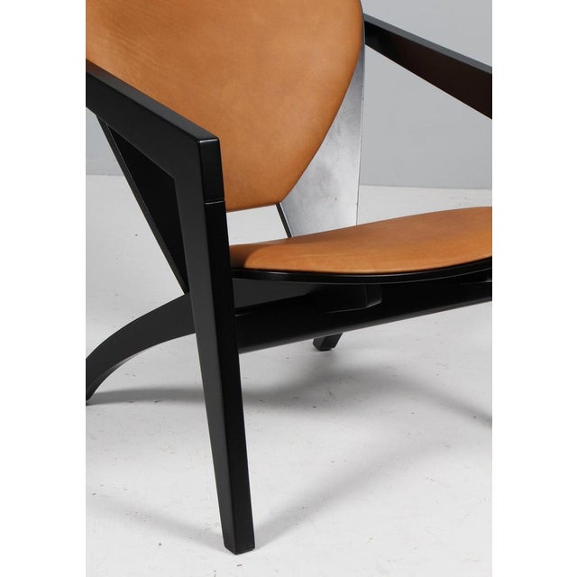 Hans j. Wegner lounge chairs new upholstered with cognac vintage aniline leather. Frame of solid new black lacquered...