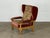 This solid oak wingback armchair by Henning Kjærnulf and was produced in Denmark during the 1960s. The turned front legs...