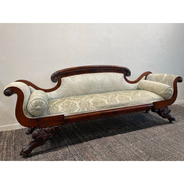 A Victorian/Georgian-style sofa from the late 1800s to early 1900s—especially one made of mahogany with claw feet—is a...