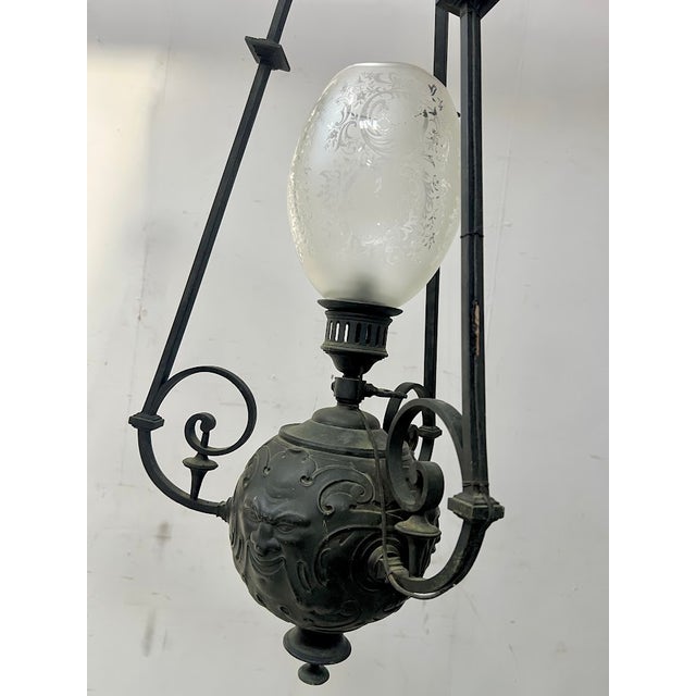 Pair of 19th-century patinated bronze chandeliers spherical model decorated with mascarons central light with a cut glass...