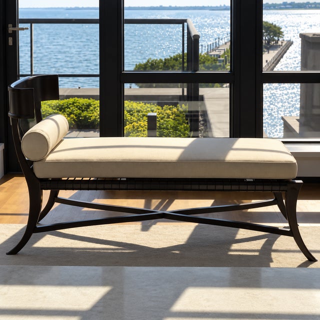 An elegant Klismos-inspired chaise lounge combining classical curves with the clean, sculptural appeal of mid-century...