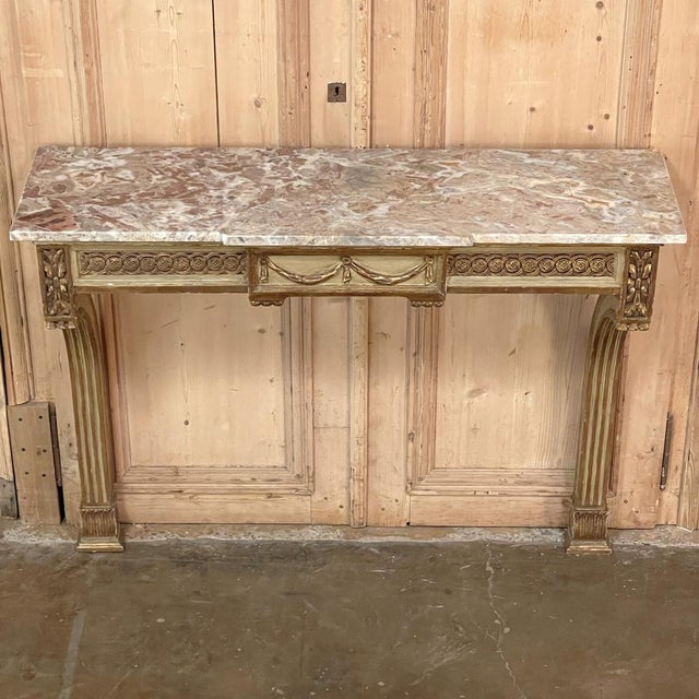 19th Century French Louis XVI Marble Top Painted Console is the ideal choice to create a stunning entryway, adorn a...