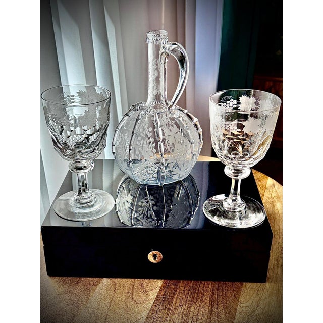 A decorative antique and vintage glassware set consisting of a 19th century claret jug and a pair of later crystal wine...