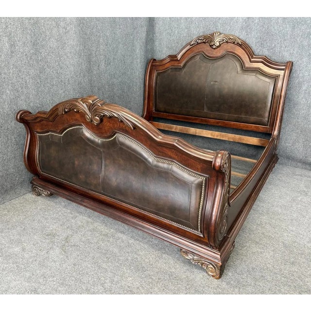 This Art Furniture Regal Collection King Size Bed Frame features an ornately carved wood frame with a sleigh-style...