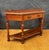 Spanish console table dating to the 20th century. The piece features a shaped top with a small raised back, a central...