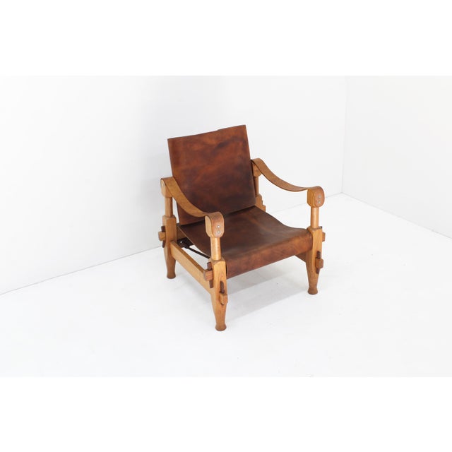 Vintage Safari armchair in thick cognac leather with wooden frame and rope details. Sculptural piece from the 1960s.