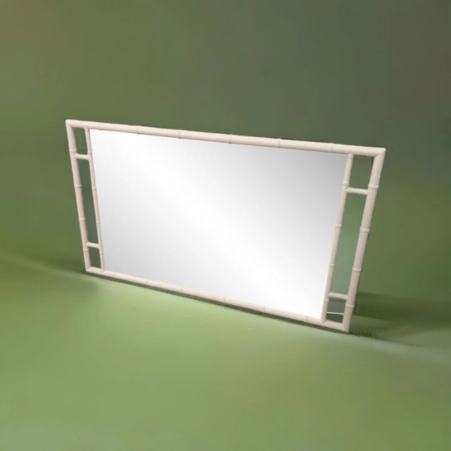 This stunning Mid Century mirror is made by Kittinger Furniture Craftsmen and features an off-white colored bamboo-style...