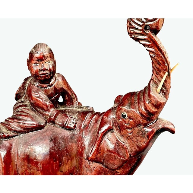 Beautiful early 20th-century rosewood elephant carving. It features an elephant with a raised trunk (symbolizing luck), a...