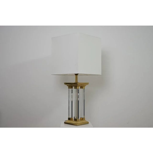 Unusual table lamp in the Hollywood Regency style from the 1970s. Made in brass and acrylic glass. The lamp was checked by...