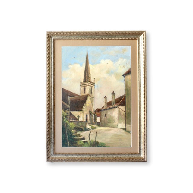 Charming midcentury painting of a quiet French village, featuring a classic church steeple under a bright sky. The artwork...