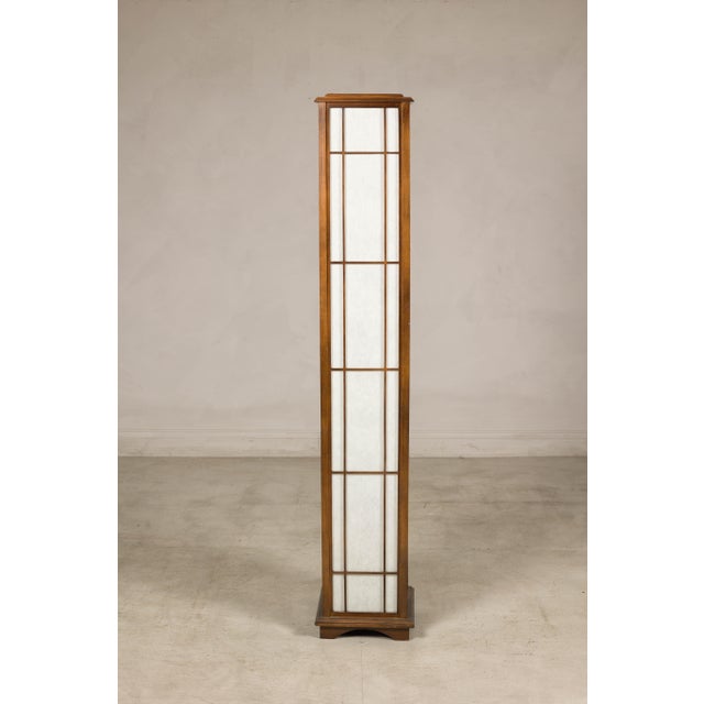 This vintage Japanese floor lamp embodies the clean geometry and quiet elegance of traditional shoji design. The tall,...