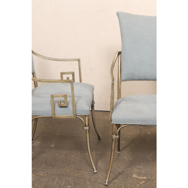 A French set of four aluminum and upholstered dining chairs. These vintage chairs from France each feature elegantly cast...