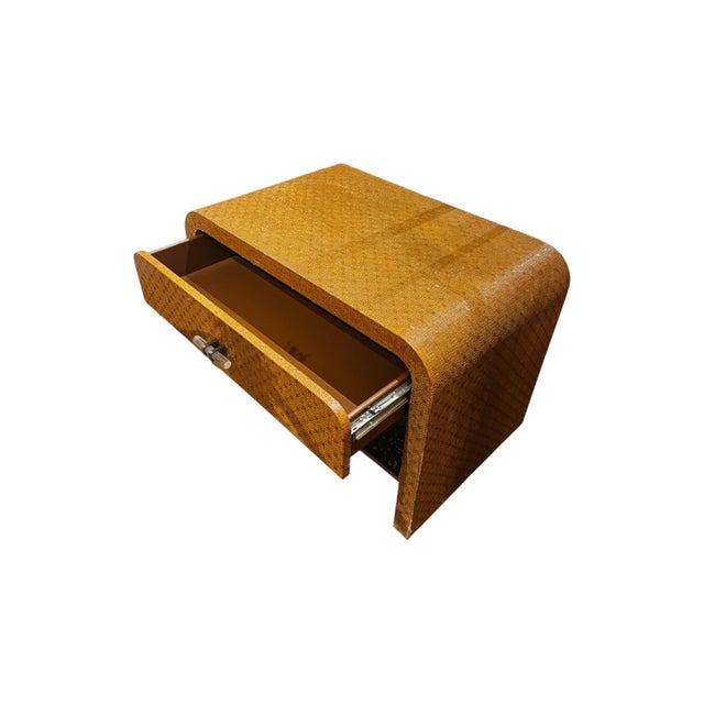 Tommy Bahama–style wicker side table featuring a warm honey-toned woven finish, rounded edges, a single drawer with unique...